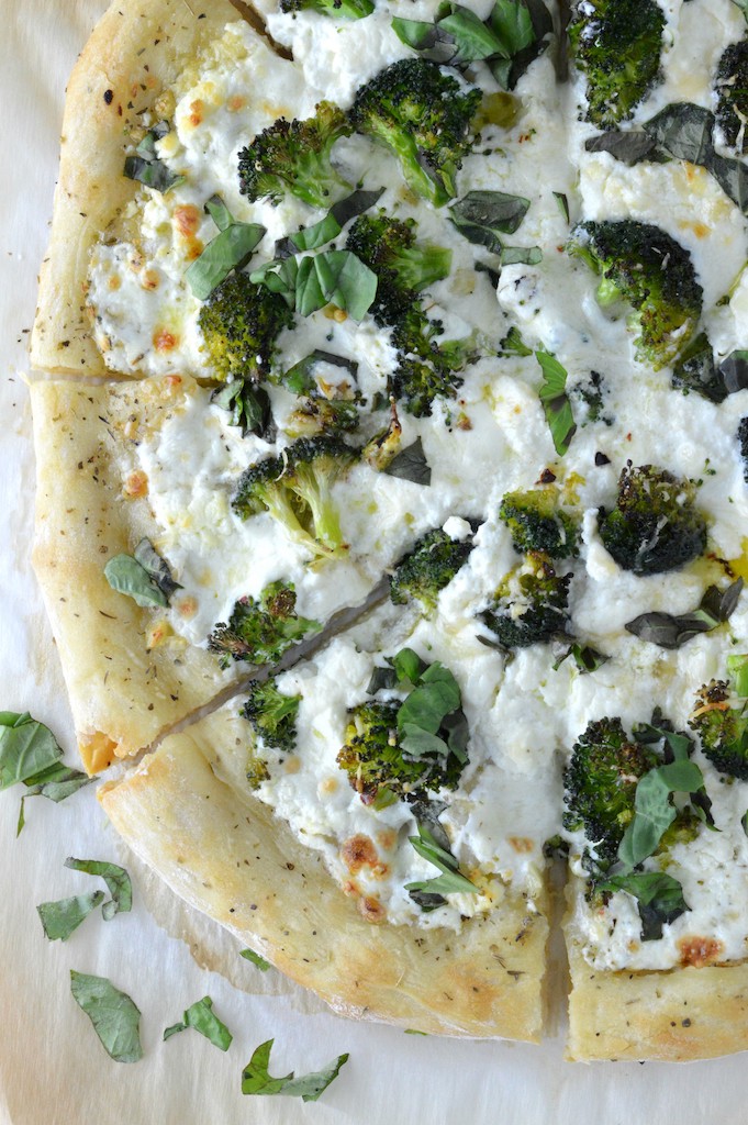 overhead shot of sliced broccoli pizza on parchment paper
