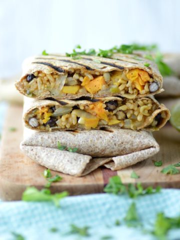 close-up of sweet potato black bean burritos stacked on each other