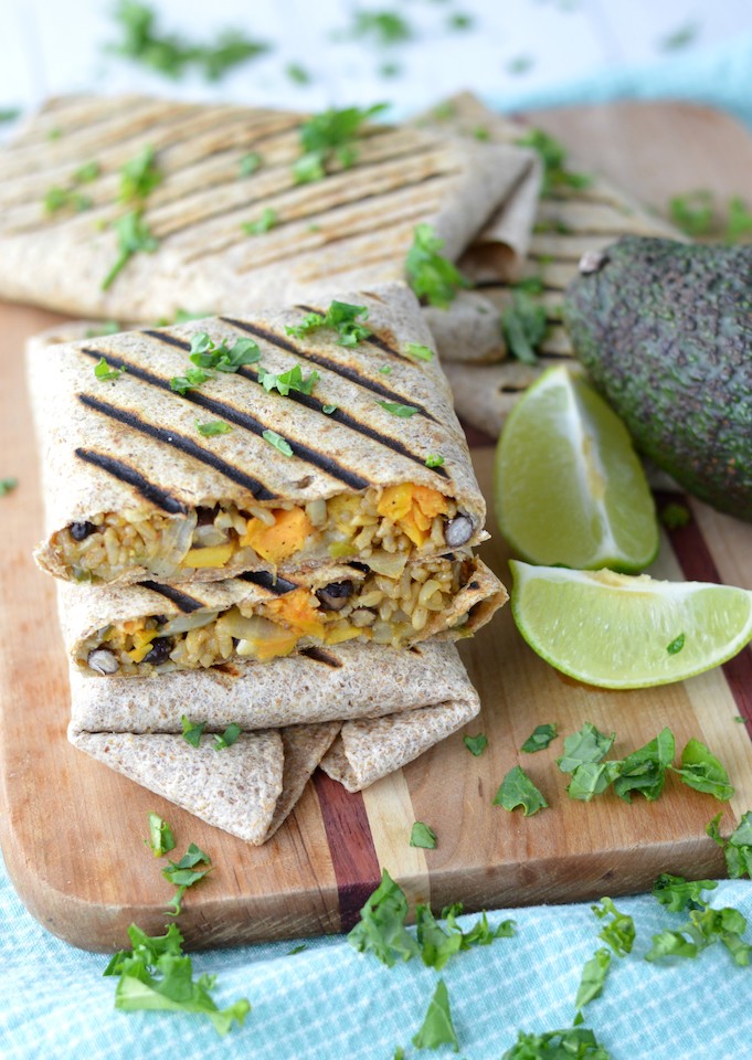 vegetarian burritos stacked on each other on cutting board