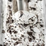 cookies and cream ice cream being scooped out of metal tin