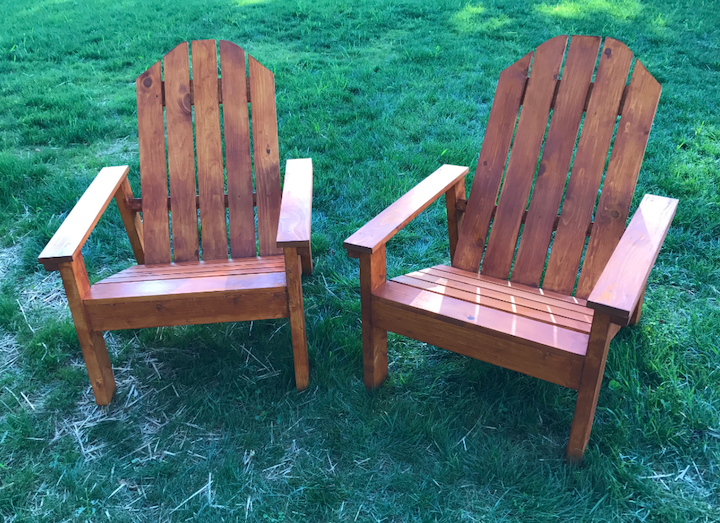 two homemade Adirondack chairs that are stained built from plans