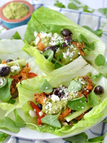 close-up of three Greek chicken lettuce wraps on white plate