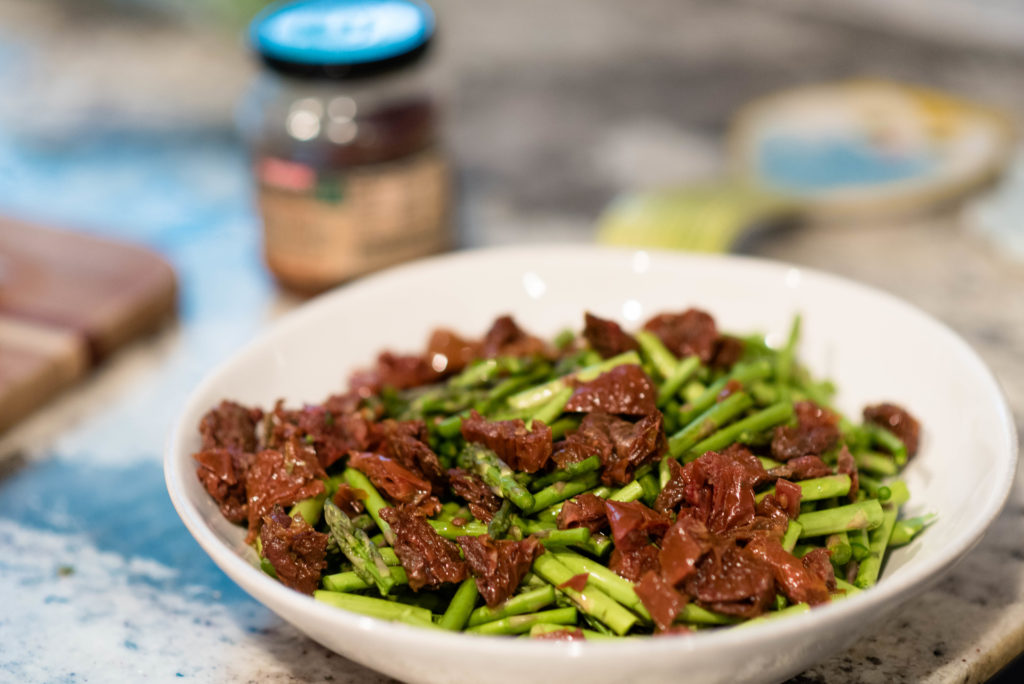 sun-dried tomatoes and chopped asparagus in white bowl