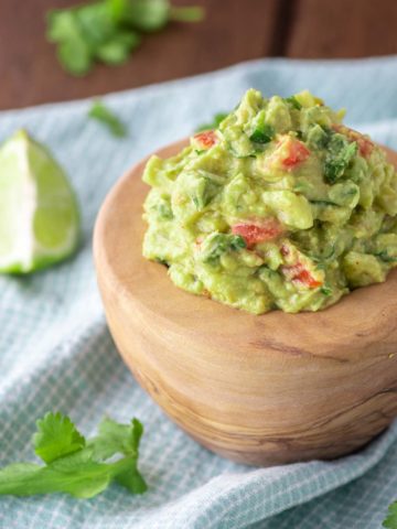 close-up of authentic guacamole in wooden bowl