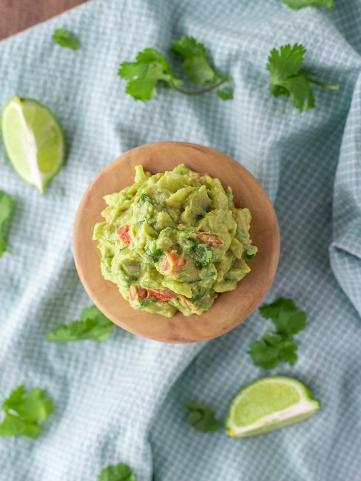 overhead shot of authentic guacamole in wooden bowl