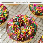 chocolate frosted donut with sprinkles on cooling rack