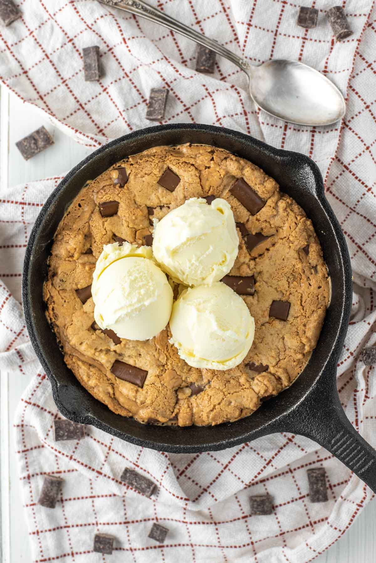 overhead shot of chocolate chip peanut butter cookie with vanilla ice cream in skillet