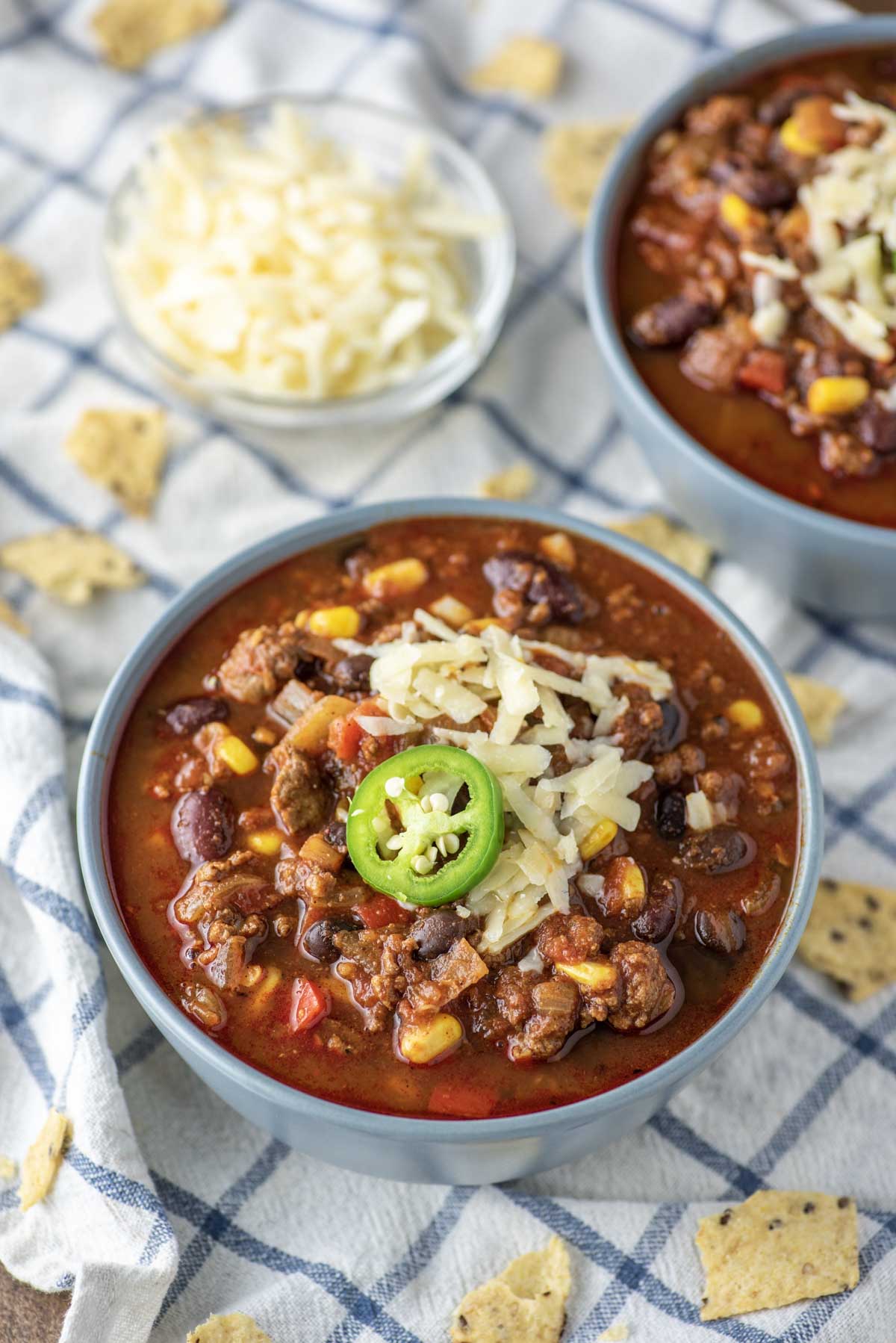 beef chili in two blue bowls on dish towel