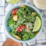 overhead shot of healthy kale caesar salad in blue bowl