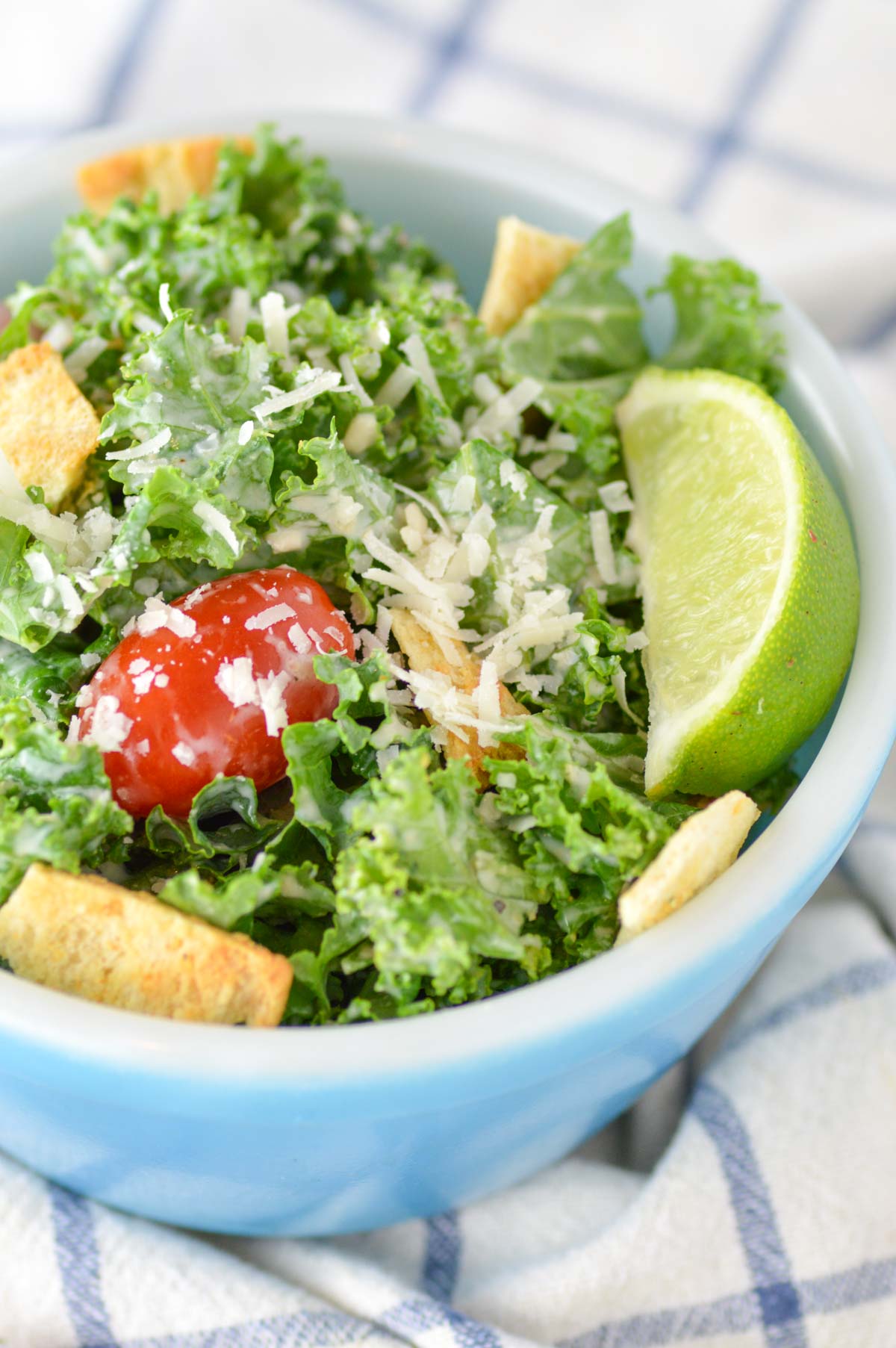 close-up of healthy kale caesar salad in blue bowl