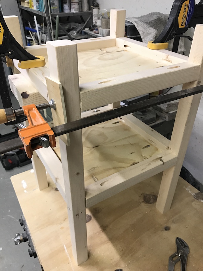 legs of table being clamped to shelves