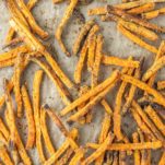 overhead shot of sweet potato fries on parchment-lined baking sheet