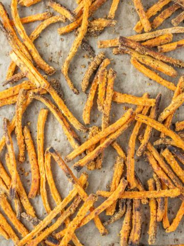 overhead shot of sweet potato fries on parchment-lined baking sheet
