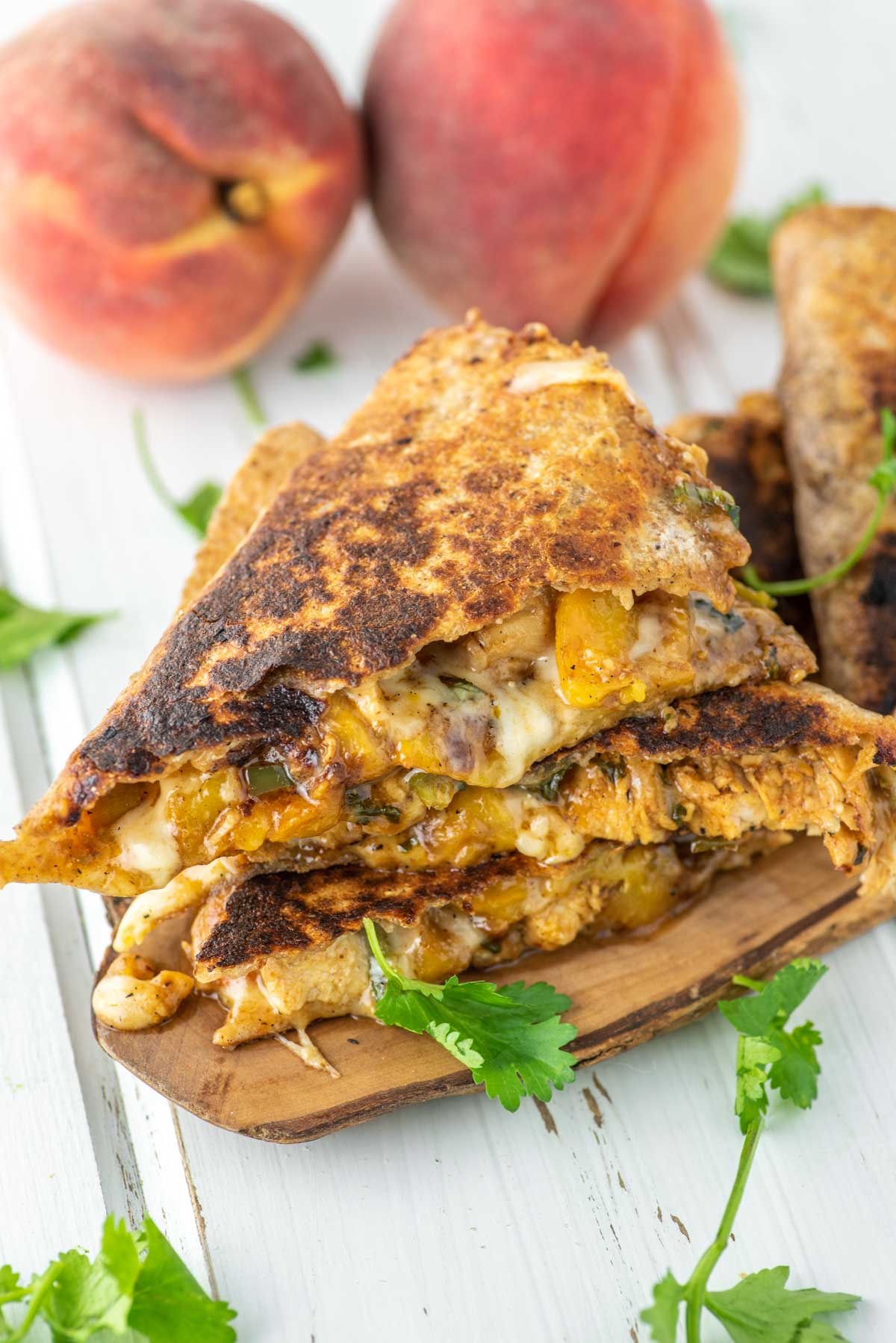stacked BBQ chicken and peach quesadillas on wood board