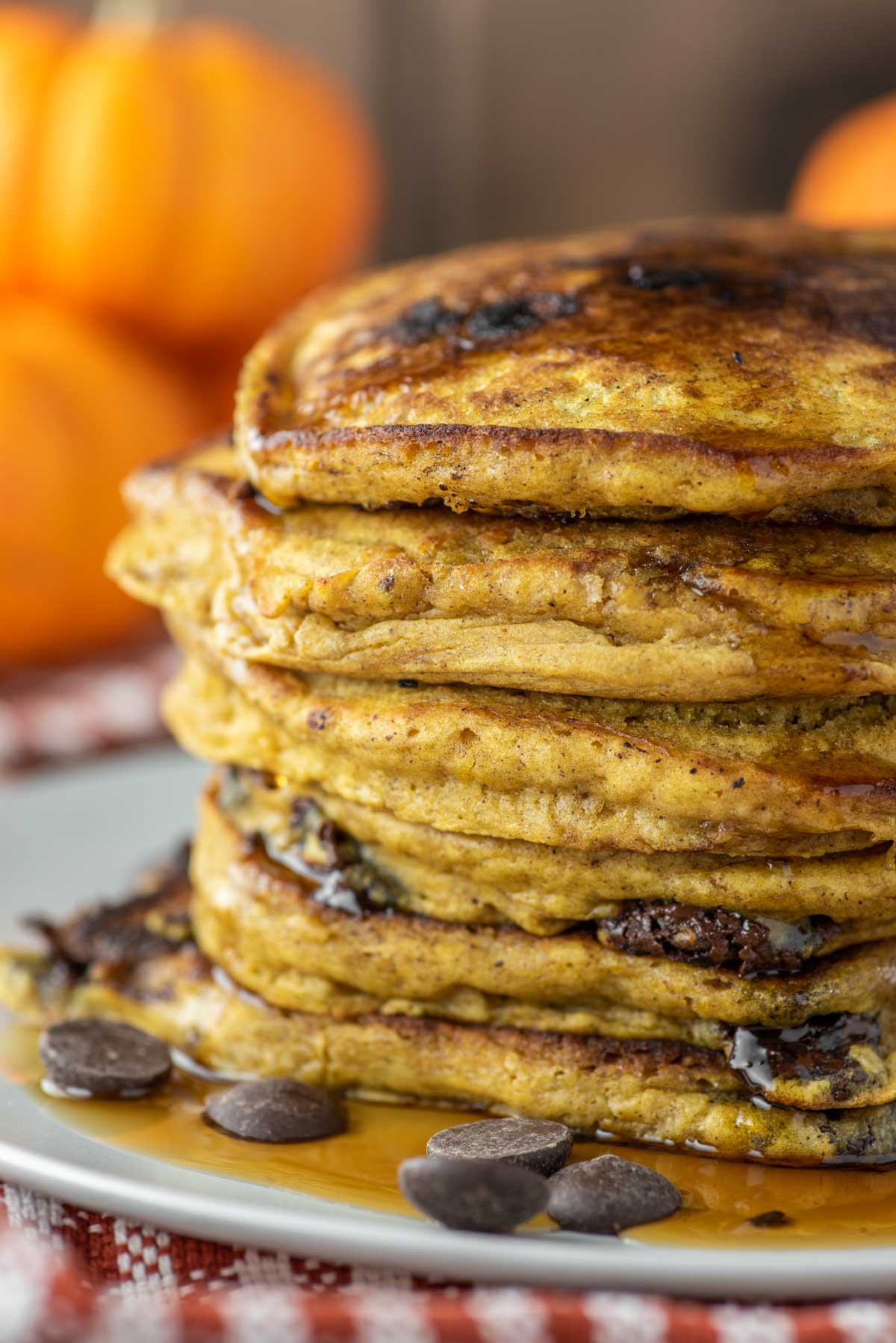close-up of stacked pumpkin chocolate chip pancakes on white plate
