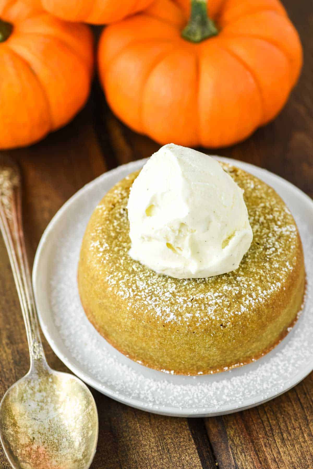lava cake made with pumpkin on white plate with ice cream on top