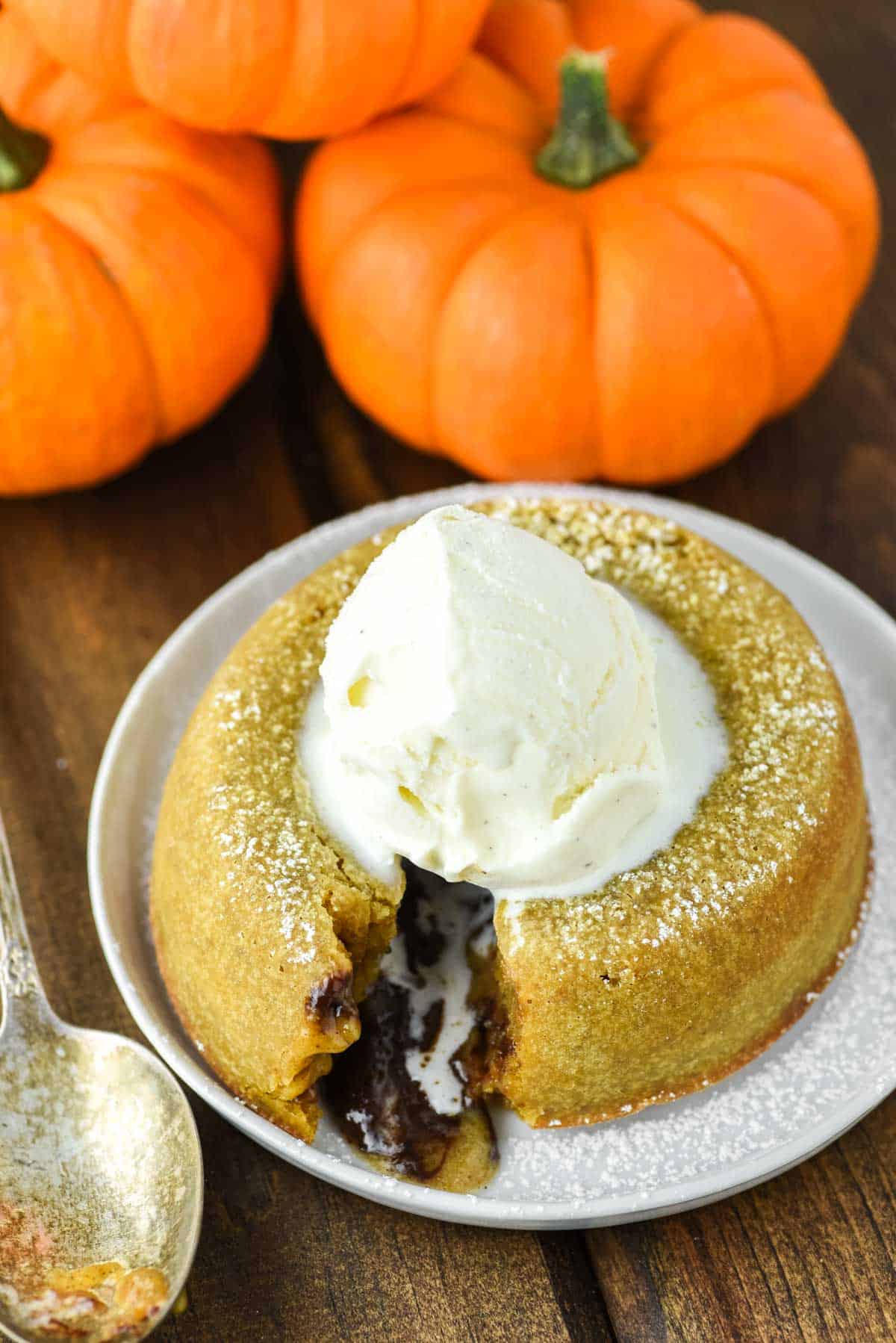 pumpkin lava cake with ganache oozing out and ice cream on top