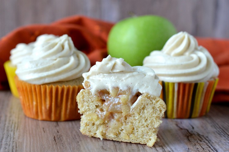close-up of four apple pie cupcakes with one cupcake cut open
