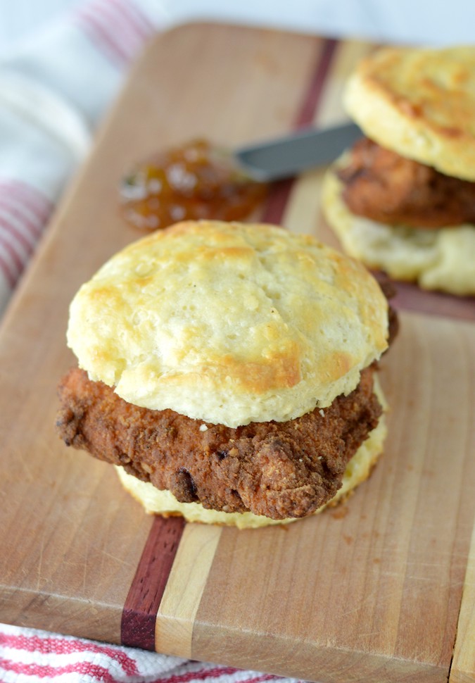 close-up of two copycat Chick-fil-A chicken biscuits on wood cutting board