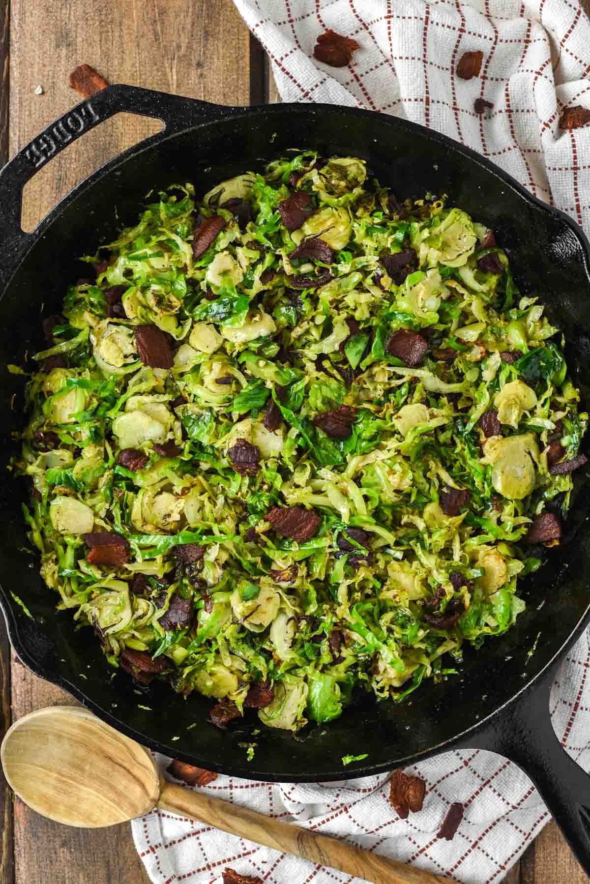 overhead shot of shaved brussels sprouts with bacon in skillet