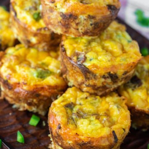 hash brown egg muffins stacked on top of wood board
