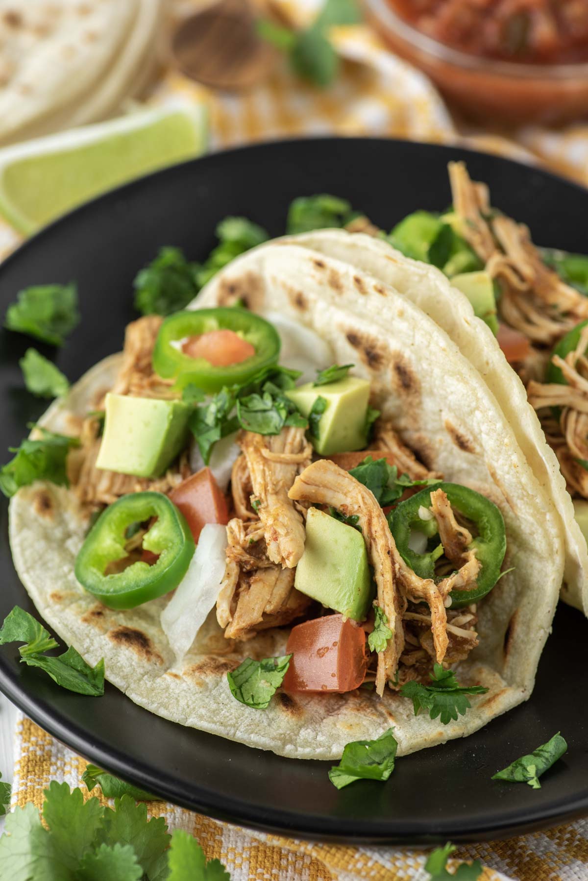 two Instant pot chicken tacos on black plate