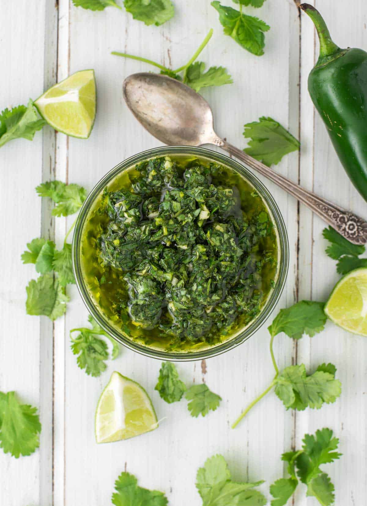 overhead shot of chimichurri in glass bowl with spoon