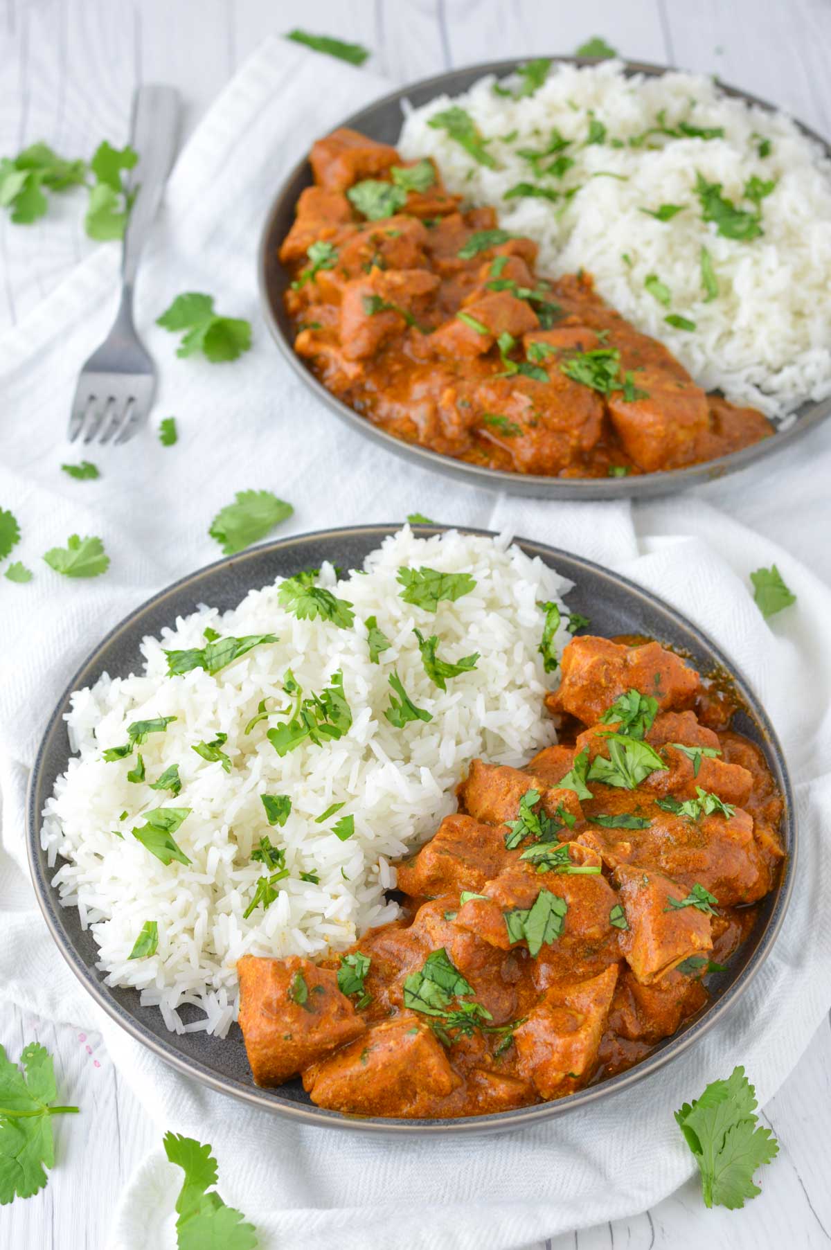 close-up of slow cooker Indian butter chicken in two slate plates