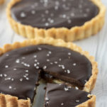 close-up of chocolate caramel tart with one slice cut