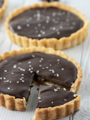 close-up of chocolate caramel tart with one slice cut
