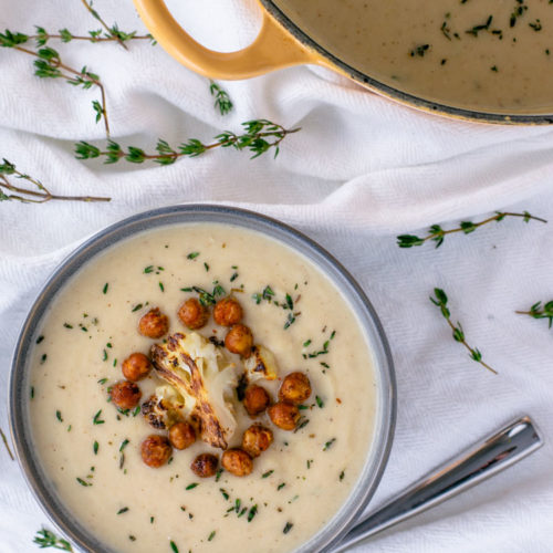 overhead shot of creamy roasted cauliflower soup in gray bowl