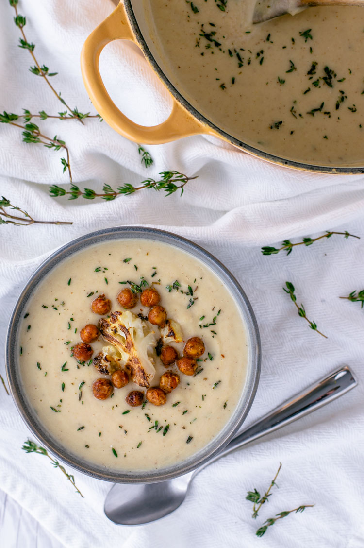 overhead shot of creamy roasted cauliflower soup in gray bowl