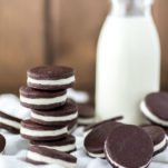 close-up of stacked oreo cookies on white kitchen towel with glass of milk