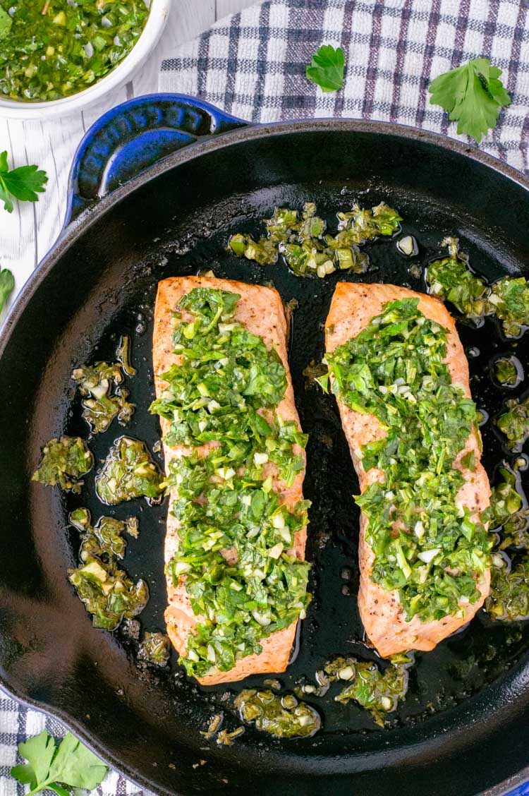 overhead of salmon with chimichurri in skillet
