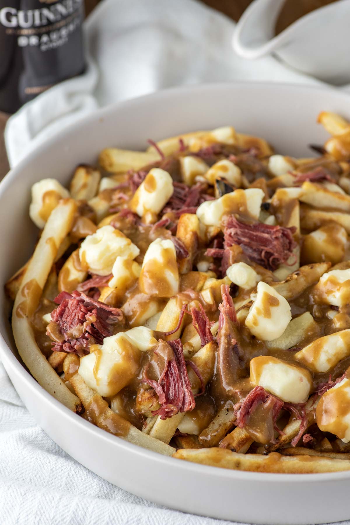 corned beef poutine in white bowl on dish towel
