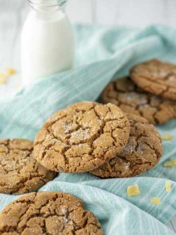 ginger cookies on teal dish towel with glass of milk
