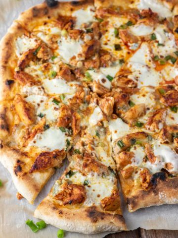 slice of buffalo chicken pizza pulled on parchment paper