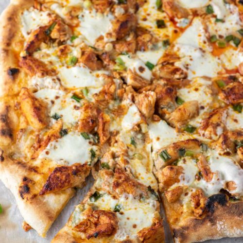 slice of buffalo chicken pizza pulled on parchment paper