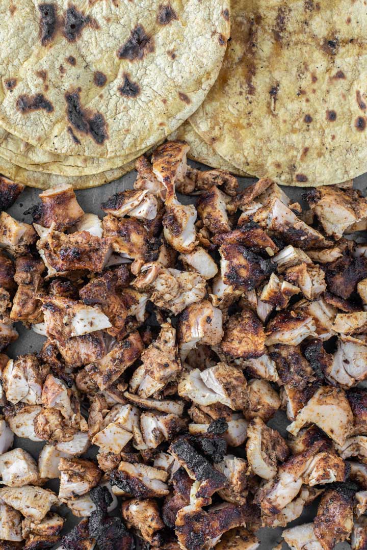overhead shot of chopped grilled chicken with corn tortillas