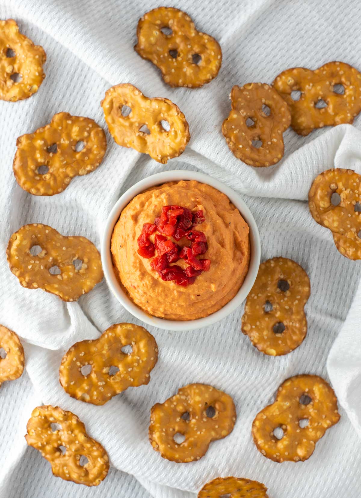 overhead shot of roasted red pepper hummus in white ramiken