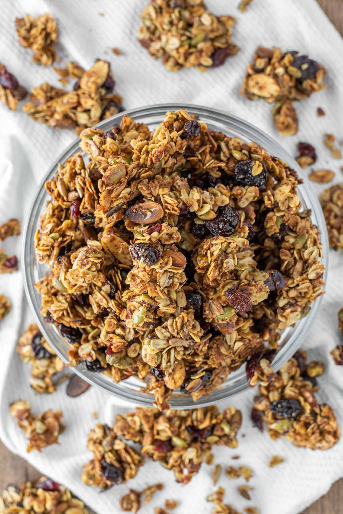 overhead shot of fruit and nut granola in glass bowl