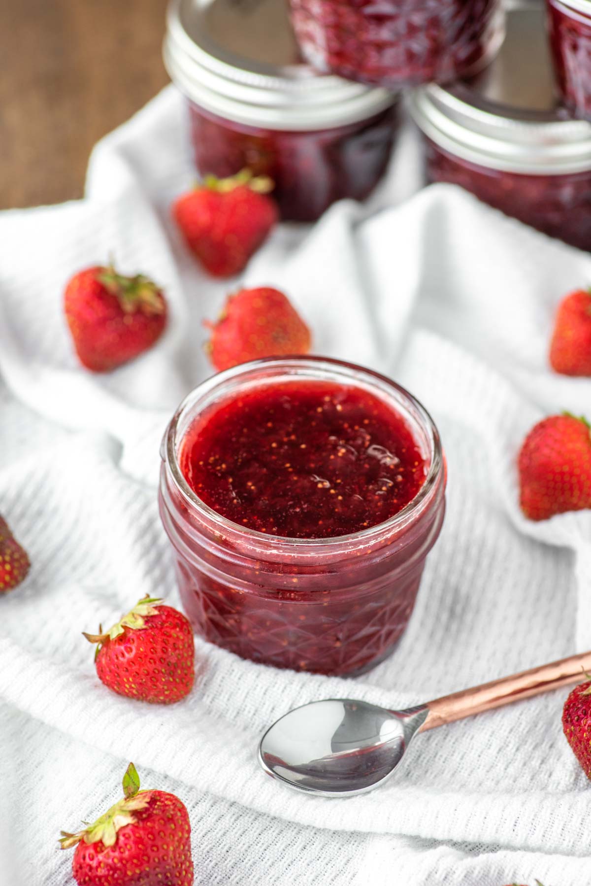 strawberry jam in jar on dish towel