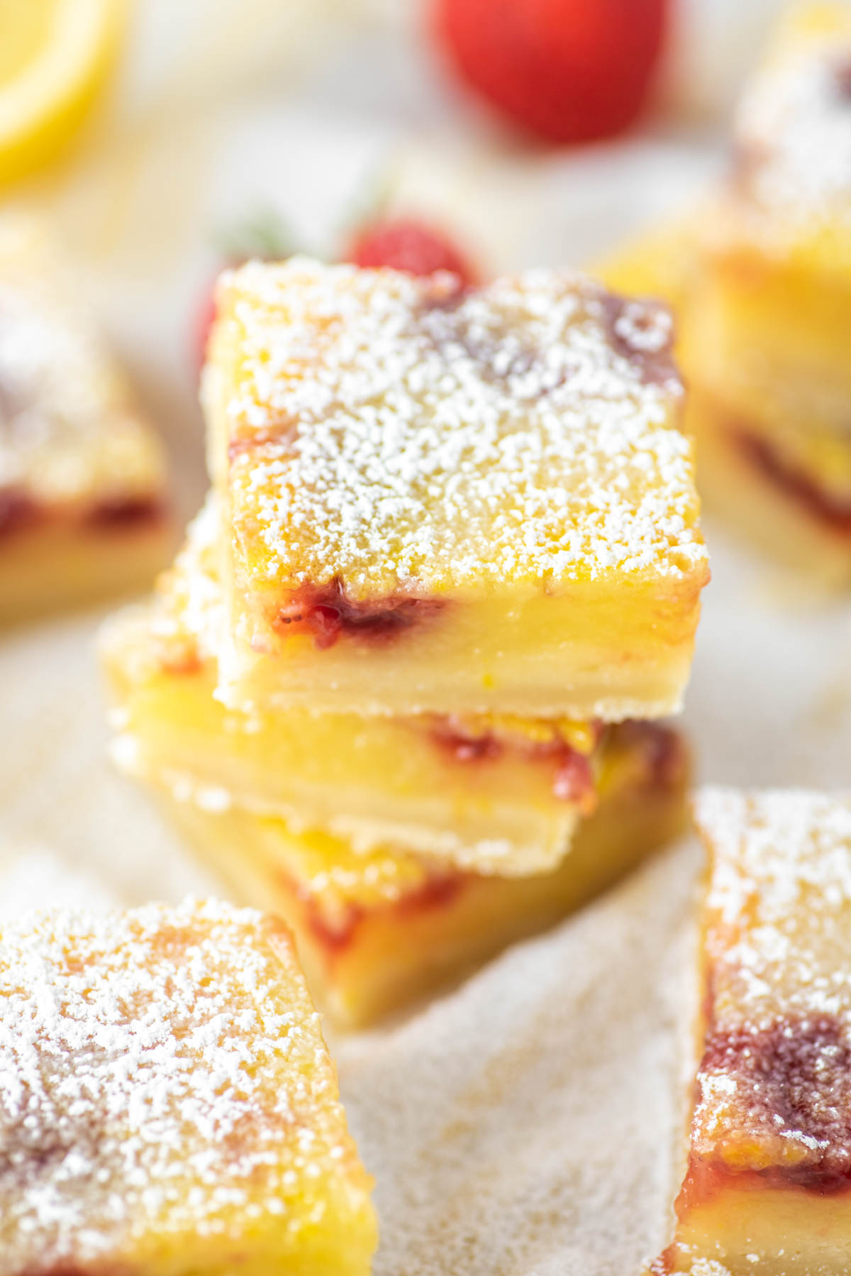 strawberry lemon bars stacked on top of each other on dish towel