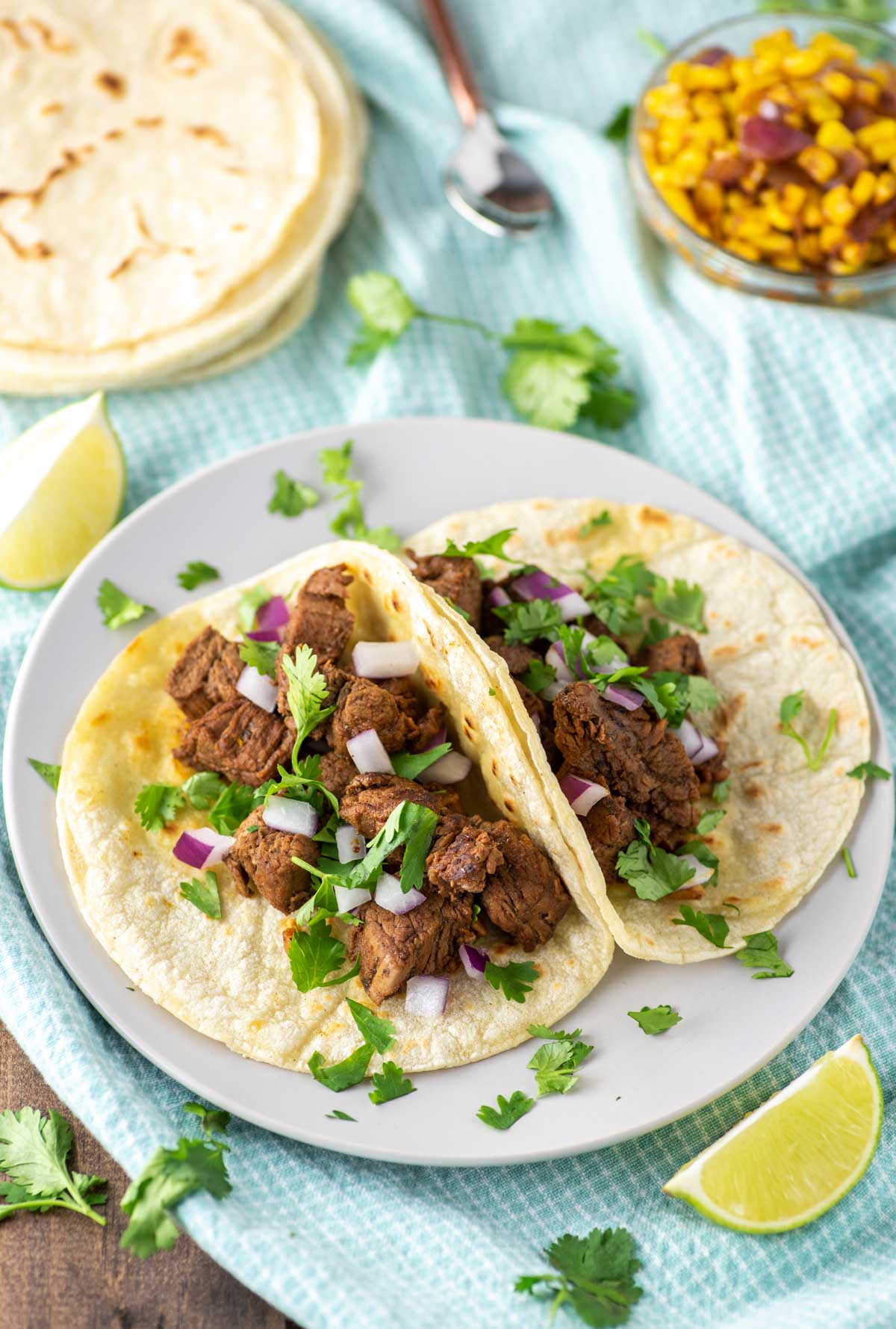 two carne asada tacos on plate on dish towel