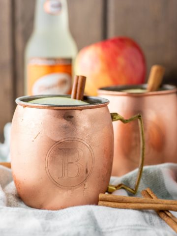 two apple cider moscow mules in copper cups