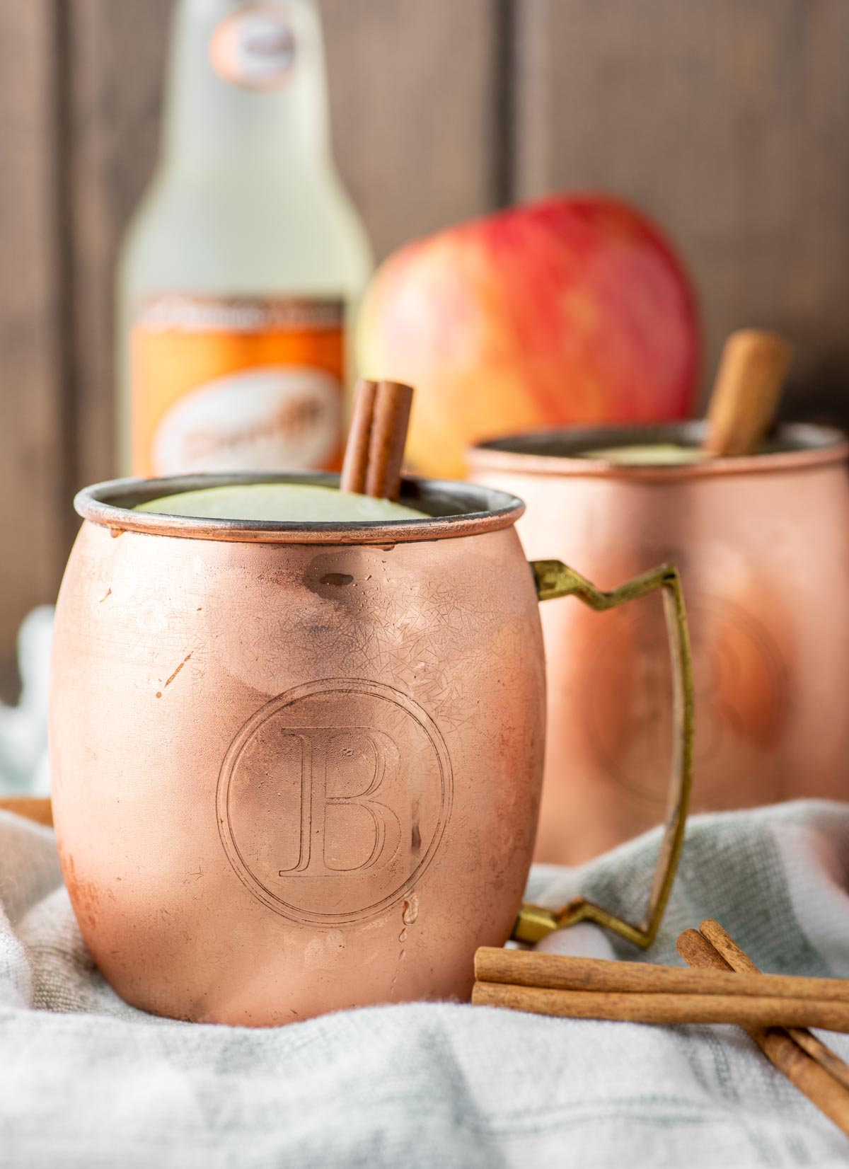 two apple cider moscow mules in copper cups