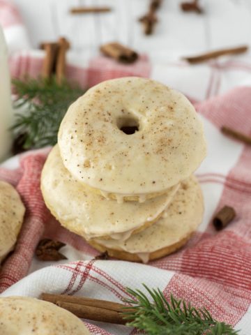 three eggnog donuts stacked on dish towel