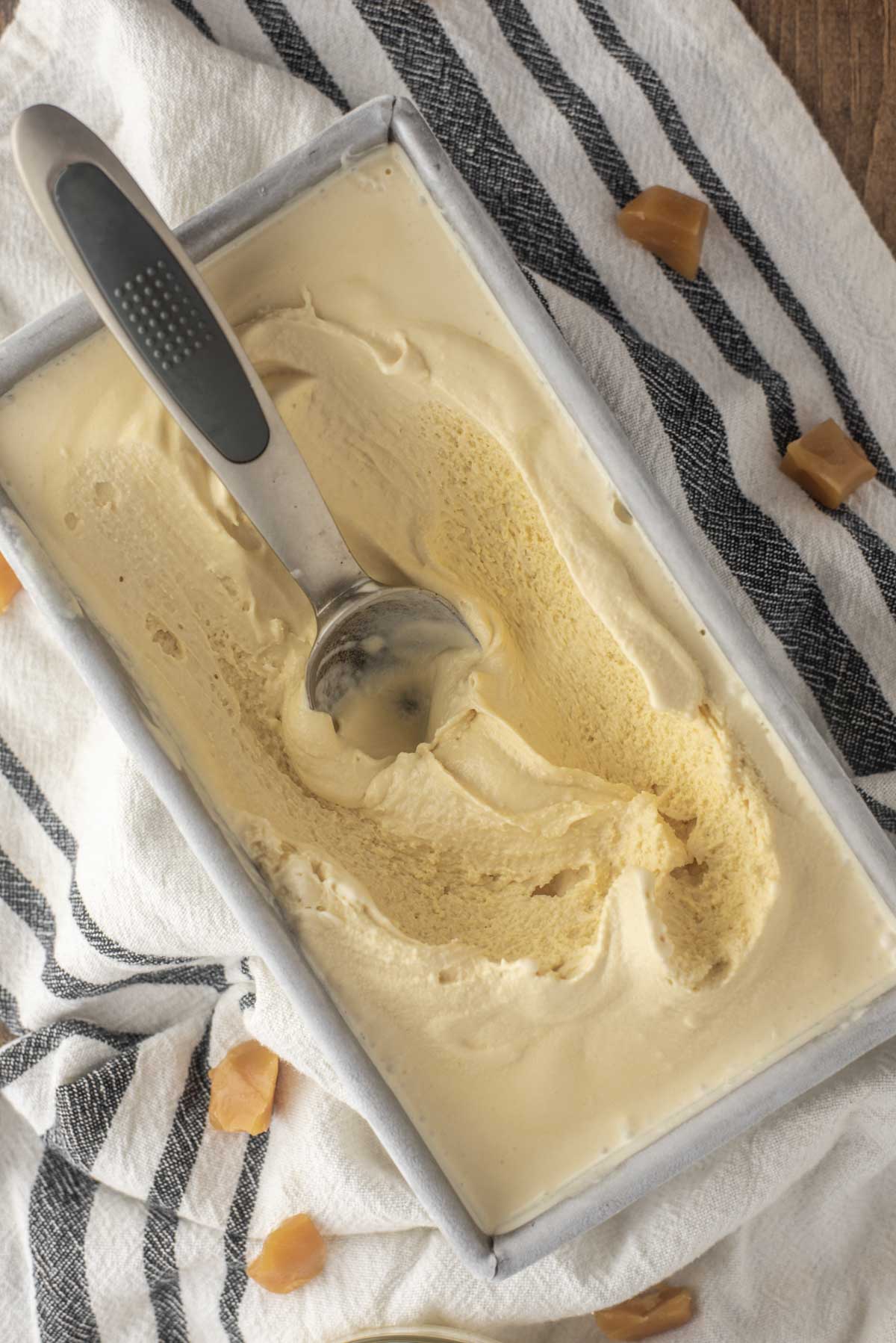 overehead shot of scooped out salted caramel ice cream in metal tin