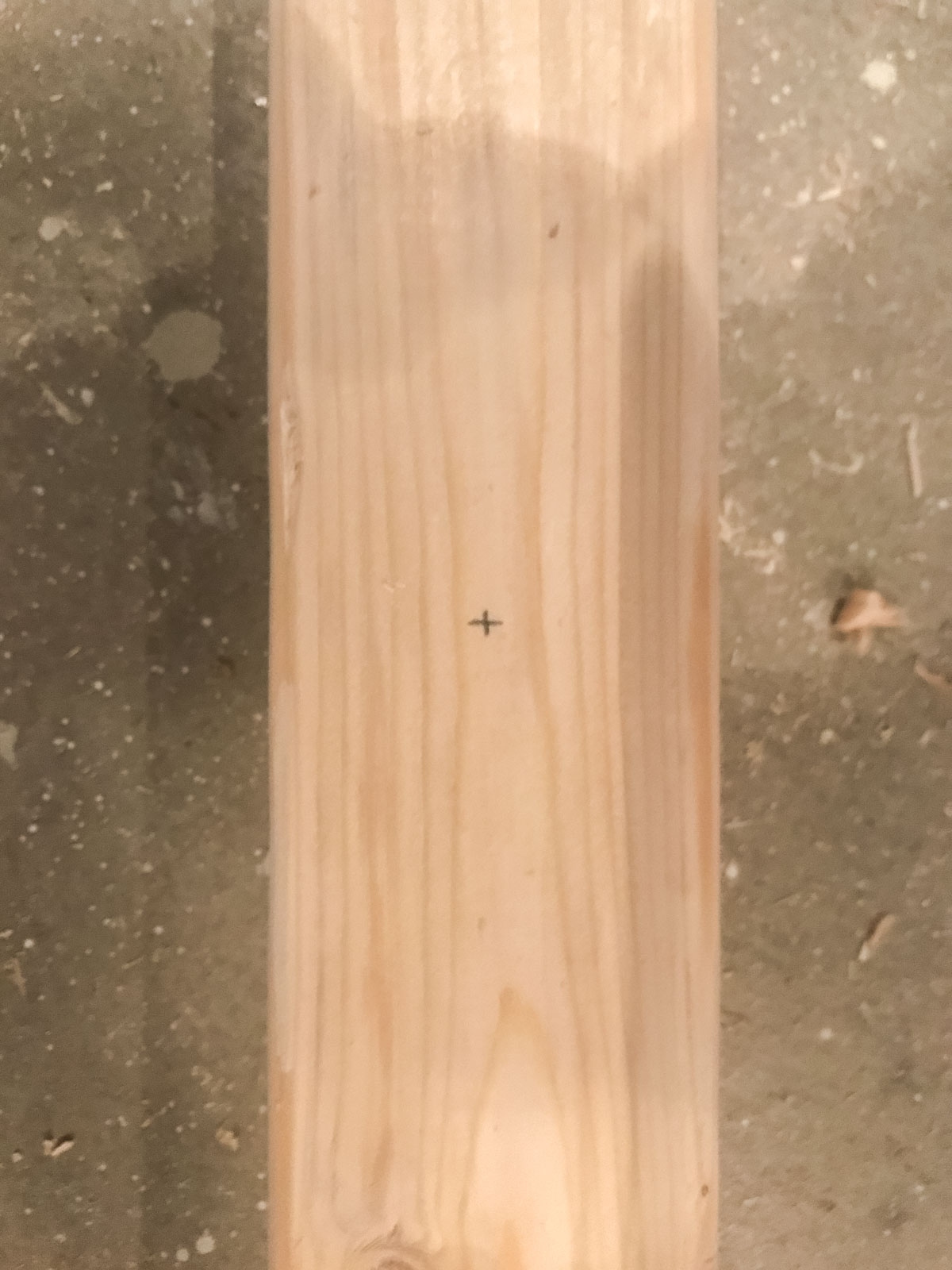 middle of 2x3 wood marked for drilling