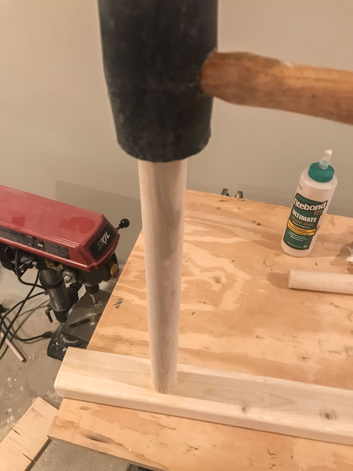 rubber mallet hammering dowel into ladder leg